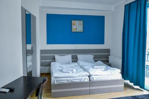 Cama en habitación con pared azul en City Hotel Kutaisi en Kutaisi