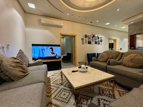 a living room with two couches and a tv at شقة ارضية مدخل خاص ٤ غرف نوم النرجس ١ in Riyadh
