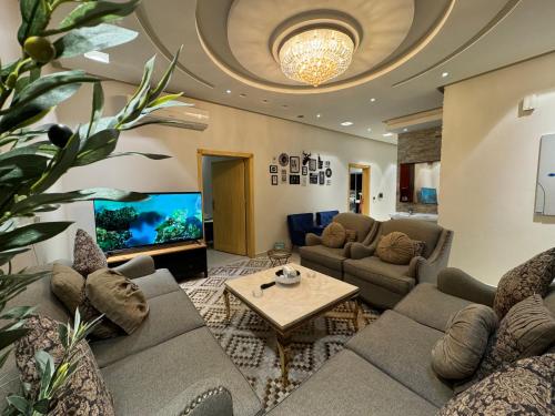 a living room with a couch and a tv at شقة ارضية مدخل خاص ٤ غرف نوم النرجس ١ in Riyadh