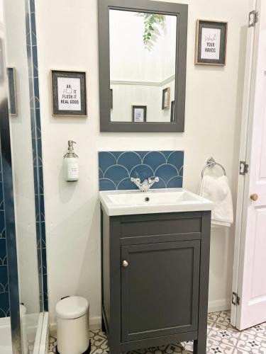 a bathroom with a sink and a mirror at Nine Cooper Lane, Holmfirth in Holmfirth