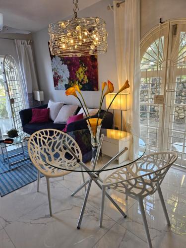 a glass table and chairs in a living room at Emerald Garden in Ocho Rios