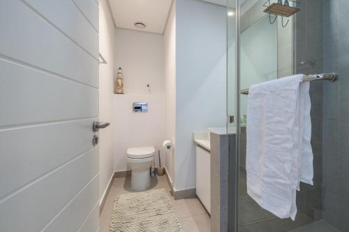 a bathroom with a toilet and a glass shower at Luxurious Ocean Dune Unit in Umhlanga