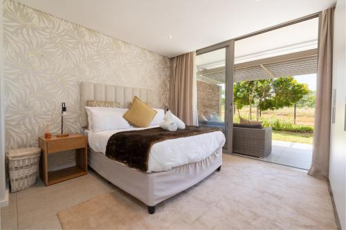 a bedroom with a bed and a sliding glass door at Luxurious Ocean Dune Unit in Umhlanga