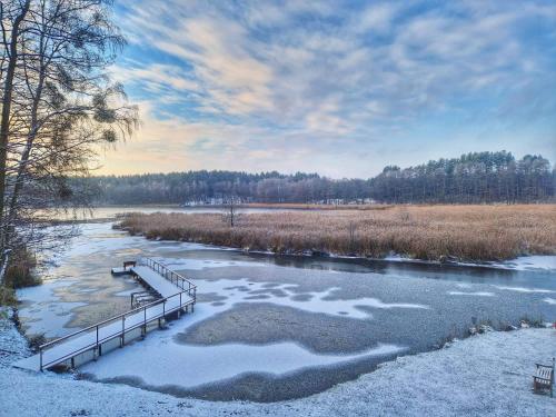 a bridge over a river with snow on it at Miško kraštas in Vileikiai