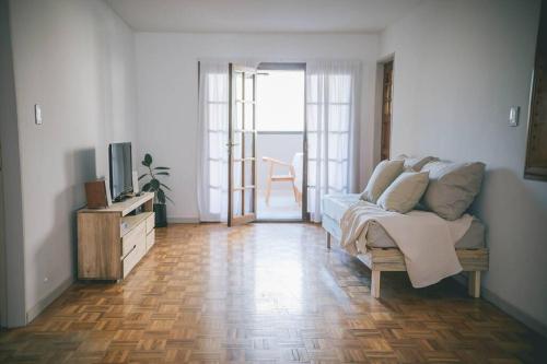 ein Wohnzimmer mit einem Sofa und einem TV in der Unterkunft Amplio departamento en Mitre 565 in Mendoza