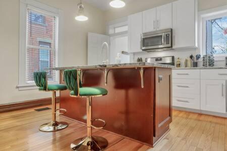 a kitchen with two green bar stools in front of a counter at Historic Elegance Retreat - Columbus Downtown in Columbus