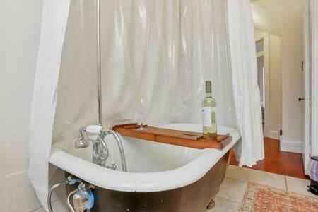 a bath tub with a bottle of wine in a bathroom at Historic Elegance Retreat - Columbus Downtown in Columbus