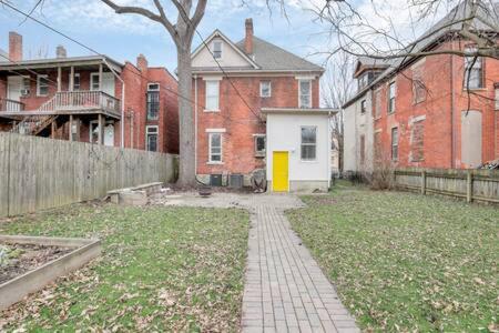 a house with a yellow door in a yard at Historic Elegance Retreat - Columbus Downtown in Columbus