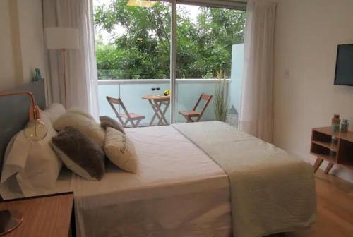 Un dormitorio con una gran cama blanca y una ventana en Palermo live en Buenos Aires