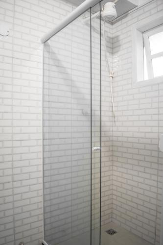 a shower with a glass door in a bathroom at Porteño Loft Búzios in Búzios