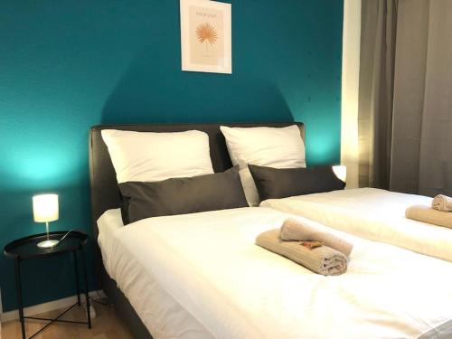 twee bedden in een slaapkamer met een blauwe muur bij LIME HOMES: Küche, Balkon, Netflix in Hildesheim