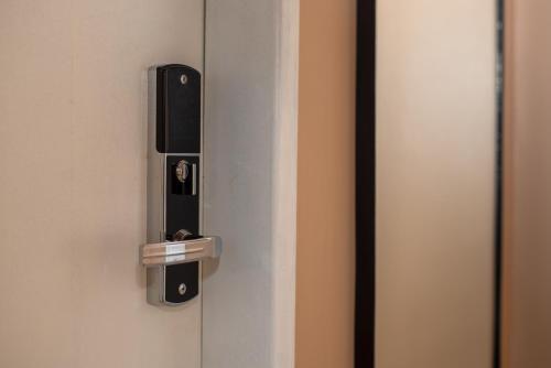 a door with a lock on a white door at Porteño Loft Búzios in Búzios