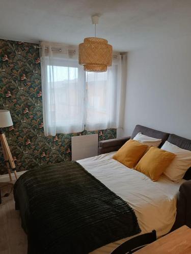 une chambre avec un lit avec des oreillers jaunes et une fenêtre dans l'établissement Charmant T2 Rénové+Parking privé, à Aucamville