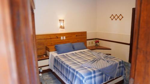 a small bedroom with a bed with blue sheets at Pousada Costa Azul in Barra Grande