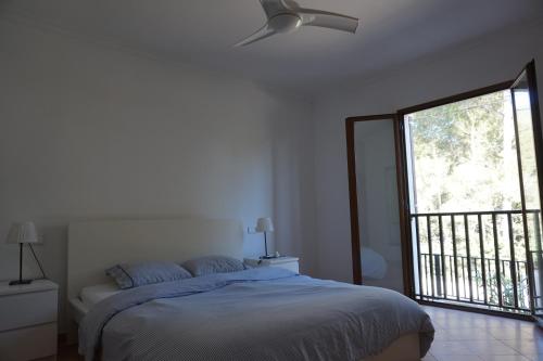 una camera con letto e ventilatore a soffitto di Chalet Font de Sa Cala a Font de Sa Cala