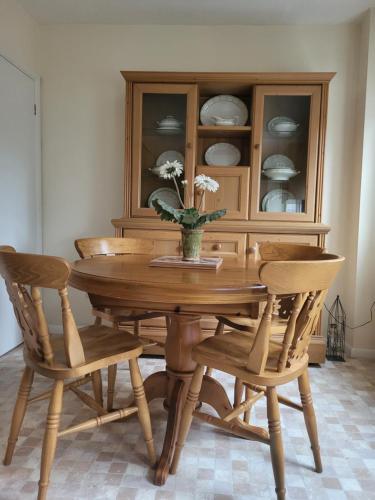 una mesa de comedor con sillas y un jarrón con flores en Grayz Townhouse - Free onsite parking for 2 cars, en Lincoln