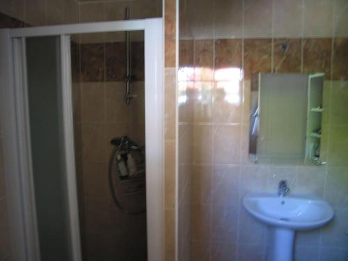 a bathroom with a sink and a shower with a mirror at 3 bedroom House very close to Paris in Pantin