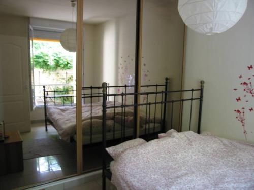 a bedroom with two beds and a large mirror at 3 bedroom House very close to Paris in Pantin