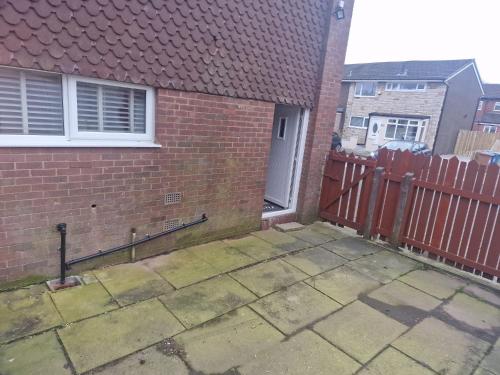 a brick house with a fence and a door at Premier inn comfort mattresses - sleeps 6 in Middleton
