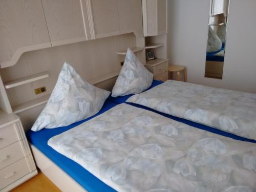 1 Schlafzimmer mit 2 Betten und weißen Kissen in der Unterkunft Ferienwohnungen Ricken in Willingen