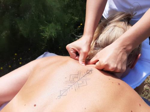 una mujer recibiendo un masaje de espalda de un terapeuta en Maison d'hôte de l'Aber - Lavande, en Crozon