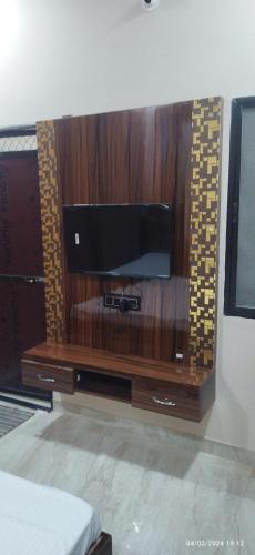 a entertainment center with a flat screen tv on a wall at Hari Har vila house Air conditioner Full vila for rent in Ujjain