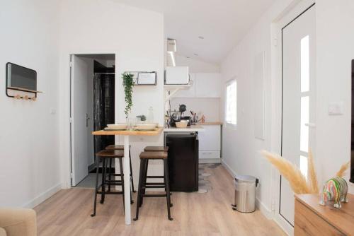 une cuisine avec un comptoir et des tabourets dans une pièce dans l'établissement Superbe T2 au coeur de Lalande+Parking privé, à Toulouse