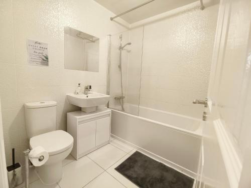 ein weißes Badezimmer mit Toilette und Waschbecken in der Unterkunft Shared House - 10 mins from Piccadilly Station/Man Uni/O2 Apollo in Manchester