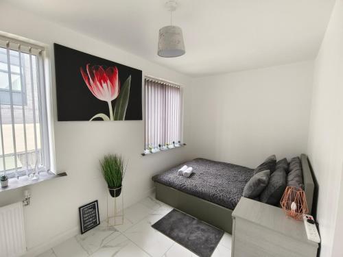 ein Schlafzimmer mit einem Sofa und einer roten Blume an der Wand in der Unterkunft Shared House - 10 mins from Piccadilly Station/Man Uni/O2 Apollo in Manchester
