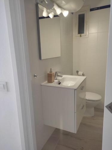 a white bathroom with a sink and a toilet at Apartamento en Binibeca Nou in Binibeca