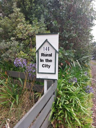 um sinal que se lê na cidade em um jardim em Rural in the city em Palmerston North