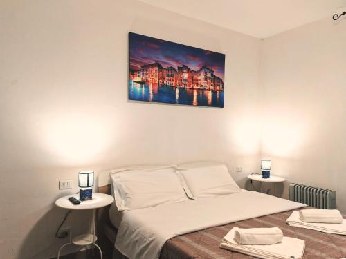 ヴェネツィアにあるGoldmine Guest House 1のベッドルーム1室(ベッド1台、テーブル2台付)、壁に絵画が備わります。