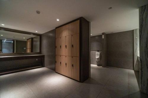 a room with a large wooden door in a bathroom at Luxury & Bright 2BR Chianti Tower Mall Access in Jakarta