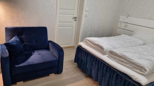 1 dormitorio con 1 cama y 1 silla azul en Holiday apartment, en Kleppstad