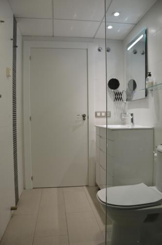 a bathroom with a toilet and a glass door at Albir Beach Apt in Albir