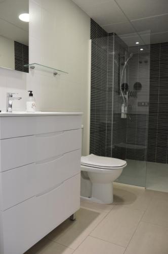 a bathroom with a toilet and a sink and a shower at Albir Beach Apt in Albir