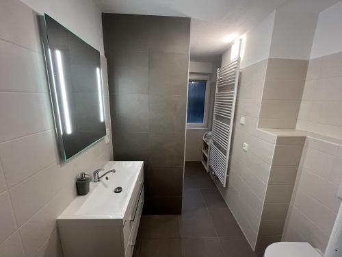 La salle de bains blanche est pourvue d'un lavabo et de toilettes. dans l'établissement Apartment Lužné, à Luhačovice