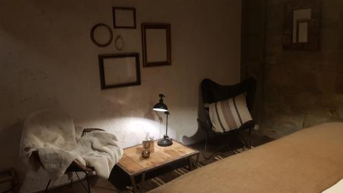 a bedroom with a bed and a table and a lamp at Le Lodge des Flâneurs in Vielsalm