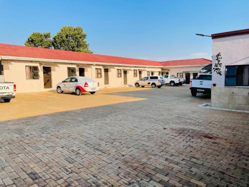 un edificio con coches estacionados en un estacionamiento en HLABISA BnB, en Hlabisa