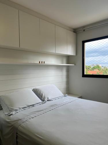 um quarto com uma cama com armários brancos e uma janela em todo climatizado, 2 quartos e piscina na 706 sul em Palmas