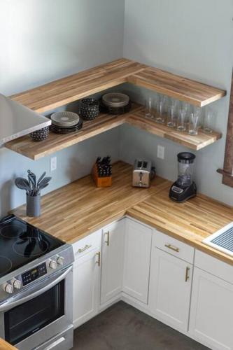 a kitchen with white cabinets and a wooden counter top at New Barndo/Kayak Launch/ 2 Private Hot Tubs in Stanton