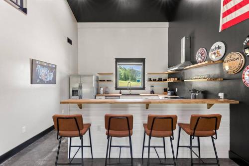 a kitchen with three bar stools and a counter at New Barndo/Kayak Launch/ 2 Private Hot Tubs in Stanton
