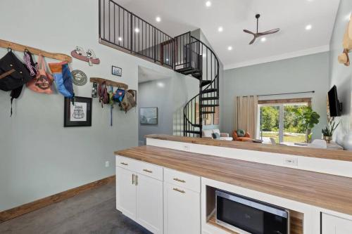 a kitchen with white cabinets and a staircase at New Barndo/Kayak Launch/ 2 Private Hot Tubs in Stanton