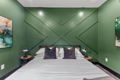 a bedroom with a large bed with green walls at New Barndo/Kayak Launch/ 2 Private Hot Tubs in Stanton