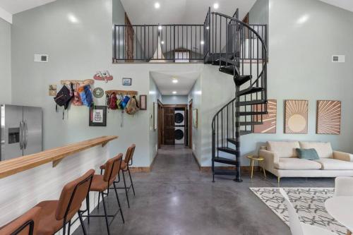 a living room with a spiral staircase and a couch at New Barndo/Kayak Launch/ 2 Private Hot Tubs in Stanton