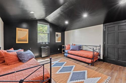 a bedroom with two beds and a black wall at New Barndo/Kayak Launch/ 2 Private Hot Tubs in Stanton