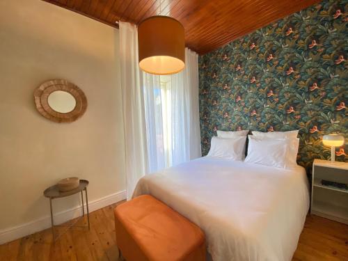 a bedroom with a large bed with a floral wall at Casa dos Frades in Vinhais