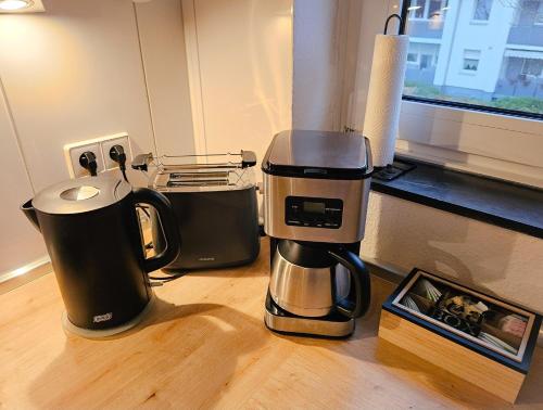 a coffee maker sitting on top of a wooden table at EcoCube 142 - Balkon, 3Zimmer, Schlafsofa, Waschmaschine, Backofen, 6Pers in Meppen