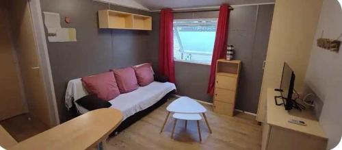 Cette petite chambre comprend un canapé et une table. dans l'établissement Mobil home Oasis Village 5*, à Puget-sur Argens