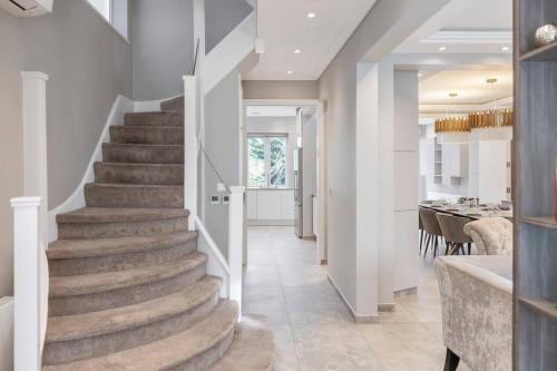 a staircase leading to a dining room and a kitchen at Mansion with jacuzzi in London 7 min from Station in London